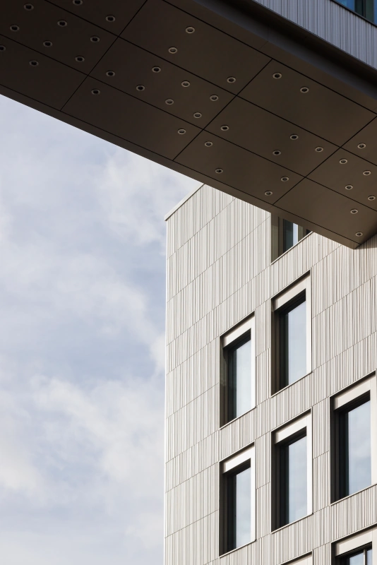 Detailansicht der hochprofilierten, vertikalen Keramikfassade am Marmorvej-Gebäude, die die präzise Verarbeitung und das innovative Design betont.