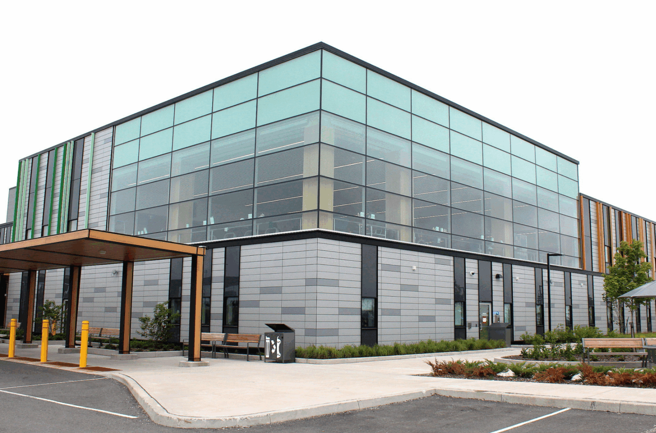 Modernes zweistöckiges medizinisches Zentrum mit Glasfassade und überdachtem Eingang.